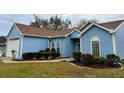 Well-manicured landscaping complements this blue home's inviting front entrance at 11484 Sw 76Th Cir, Ocala, FL 34476