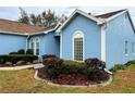 A charming blue home features a glass block window and mature landscaping at 11484 Sw 76Th Cir, Ocala, FL 34476