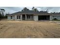 New construction home showcasing gray exterior and attached two-car garage on expansive lot at 13418 Sw 60Th Court Rd, Ocala, FL 34473