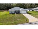 Single story home featuring a pristine lawn, fresh landscaping, and an inviting front entrance at 1482 Ne 160Th Pl, Citra, FL 32113