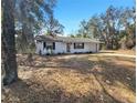 Quaint single-story home surrounded by mature trees and natural landscaping at 18 Juniper Pass Crse, Ocala, FL 34480