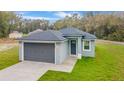 Attractive single-story home with a gray exterior, complemented by a matching roof and garage door at 47 Sequoia Loop, Ocklawaha, FL 32179