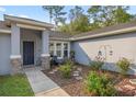 Inviting front entry with stone accents, decorative plants, and a cozy seating area at 5488 Nw 61St Ave, Ocala, FL 34482