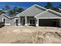 Gray single Gathering home with an attached two car garage and unfinished front yard at 6943 Sw 179Th Court Rd, Dunnellon, FL 34432