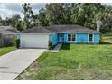 Charming single story home features a two car garage and verdant lawn with well-maintained landscaping at 6950 Se 124Th Ln, Belleview, FL 34420