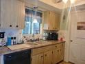 Traditional kitchen with a double sink, overhead cabinets, and a window with striped valance at 8481 Sw 107Th Pl, Ocala, FL 34481