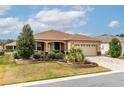 Beautifully landscaped front yard with a well-maintained lawn, decorative stone accents, and a two-car garage at 8532 Sw 79Th Ave, Ocala, FL 34481