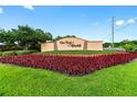 A welcoming entrance sign to 'On Top of the World', surrounded by lush landscaping and colorful flowers at 8874 Sw 104Th Cir, Ocala, FL 34481