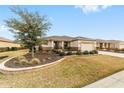 Inviting single-story home featuring well-kept landscaping, an attached two-car garage, and a cozy front porch at 8874 Sw 104Th Cir, Ocala, FL 34481