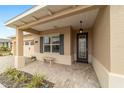 Welcoming covered porch features decorative shutters, a stone bench, and an elegant front door at 9399 Sw 106Th Ave, Ocala, FL 34481