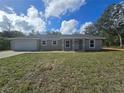 Beautiful single-story home with attached garage, showcasing its well-kept front yard at 96 Fisher Way Trl, Ocklawaha, FL 32179