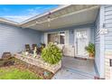 Inviting front porch featuring a seating area adorned with plants and decorative items at 9661 Se 173Rd Pl, Summerfield, FL 34491