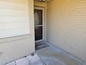 An up-close view of the front door with a Welcome mat on a painted brick exterior at 10831 Se 50Th Ter, Belleview, FL 34420