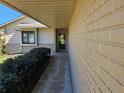 A covered front porch, leading to the front door, with a painted brick exterior at 10831 Se 50Th Ter, Belleview, FL 34420