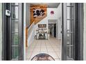 Welcoming foyer featuring tile flooring and a decorative staircase with wooden accent wall at 11684 Sw 56Th Ter, Ocala, FL 34476