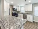 Modern kitchen featuring granite countertops, stainless steel appliances, and ample cabinet space at 12461 Se 126Th Ct, Ocklawaha, FL 32179