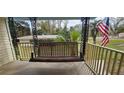 Inviting front porch swing, perfect for relaxing and enjoying the peaceful outdoor scenery at 14805 Se 51St Ct, Summerfield, FL 34491