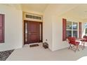 The covered entryway includes a decorative door with sidelights, and an outside seating area at 3925 Ne 58Th Cir, Silver Springs, FL 34488