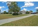 Landscaped home exterior featuring lush greenery, a well-manicured lawn, and neighborhood views at 7151 Sw 96Th Ct, Ocala, FL 34481