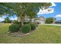 Beautiful exterior view with manicured bushes, green lawn, and a glimpse of the home's facade at 7151 Sw 96Th Ct, Ocala, FL 34481