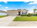 Charming single Gathering home with a two car garage and a beautiful landscaped front yard under a blue sky at 8861 Sw 63Rd Ct, Ocala, FL 34476