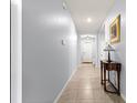 Hallway with neutral tiled flooring and light blue walls leading into a home with comfortable living spaces at 8861 Sw 63Rd Ct, Ocala, FL 34476