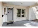 Close-up of the front door and window area with a brick facade and a small porch at 9064 Sw 91St Cir, Ocala, FL 34481