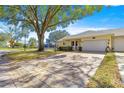 Single-story home featuring a large driveway, attached garage, and well-maintained landscaping at 9335 Sw 85Th Ter # A, Ocala, FL 34481