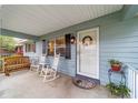 Cozy porch with rocking chairs, a bench, and a welcoming entrance with a decorative wreath and potted plant at 9348 Sw 82Nd Ter # C, Ocala, FL 34481