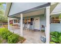 Inviting front porch with rocking chairs, bench, and a charming entrance with potted plants and decorations at 9348 Sw 82Nd Ter # C, Ocala, FL 34481