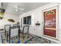 Inviting front porch with brick walls, ceiling fan, and a cozy seating area with a colorful rug at 9866 Sw 97Th Ln, Ocala, FL 34481