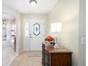 Welcoming entryway featuring a decorative front door and stylish console table with ornate lamp at 9983 Sw 90Th Loop, Ocala, FL 34481