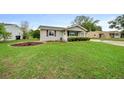 Well-manicured lawn enhances this charming single-story home with tidy landscaping at 10821 Sw 87Th Ter, Ocala, FL 34481