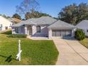 Inviting one-story home with lush green lawn, screen garage and a welcoming front entrance at 11625 Sw 71St Cir, Ocala, FL 34476