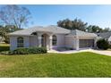 Attractive one-story home featuring a lush green lawn, screened garage and a charming entrance at 11625 Sw 71St Cir, Ocala, FL 34476