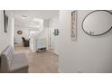 Bright entryway featuring wood floors, a bench, a round mirror, and a 