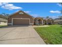 Inviting single-story home with an attached two-car garage and a neatly maintained lawn at 2301 Se 24Th Ave, Ocala, FL 34471