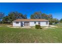 This home features a spacious backyard with a patio and an exterior constructed of solid materials at 328 Oak Track Run, Ocala, FL 34472