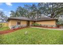 Well-maintained single-story home with stone accents, landscaping, and green lawn at 5205 Ne 3Rd St, Ocala, FL 34470