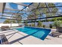 Inviting screened-in pool with tiled accents, lounge chairs, and serene backyard views at 5417 Sw 49Th Ave, Ocala, FL 34474