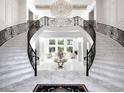 Elegant foyer with dual staircases, marble floors, a chandelier, and views to the outside living area at 8482 Nw 31St Lane Rd, Ocala, FL 34482