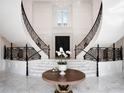 Grand foyer with dual curved staircases, marble flooring, high ceilings, and an elegant chandelier at 8482 Nw 31St Lane Rd, Ocala, FL 34482