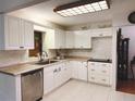 Well-lit kitchen featuring white cabinets, modern appliances, and neutral countertops at 8685 Sw 94Th Ln # B, Ocala, FL 34481