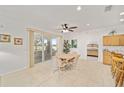 Bright dining area featuring tile floors, a ceiling fan, access to the screened-in patio, and adjacent kitchen at 8779 Sw 83Rd Cir, Ocala, FL 34481