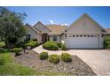 Inviting single-story home displaying well-maintained landscaping, neutral paint, and a convenient two-car garage under blue skies at 8779 Sw 83Rd Cir, Ocala, FL 34481