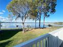 Picturesque view from a porch overlooking a pristine lake with docks, benches, and mature shade trees at 11001 Se Sunset Harbor Rd # A08, Summerfield, FL 34491