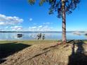Scenic lake view featuring a vibrant blue sky with scattered clouds, boat docks, and lush greenery at 11001 Se Sunset Harbor Rd # A08, Summerfield, FL 34491