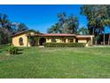 Beautiful home with a stucco exterior, red tile roof, manicured lawn, and decorative front gate at 1255 Ne 70Th St, Ocala, FL 34479