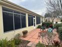 Enclosed sunroom, accessible from a tiled patio with chairs and plants at 12752 Se 91St Terrace Rd, Summerfield, FL 34491