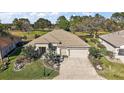 Manicured front lawn and landscaping complement the beige home with a two car garage at 13424 Se 89Th Terrace Rd, Summerfield, FL 34491